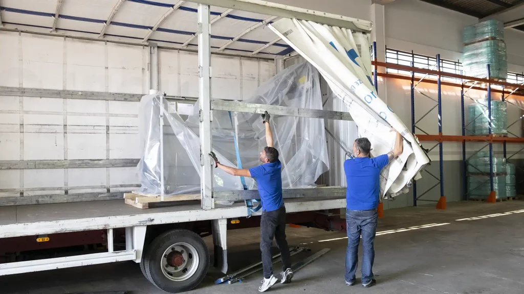 A importância do transporte na logística - Homens a carregar um camião de transporte de mercadorias